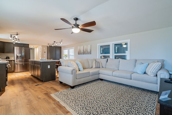 Open concept Livingroom with Roku tv, kitchen, and dining table 