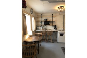 Eat in kitchen area with stove, fridge and other small appliances.