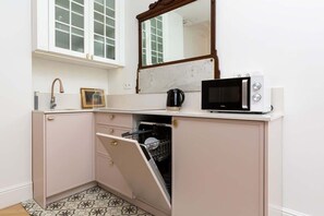 Kitchenette with plenty of kitchen utensils and dishes. 