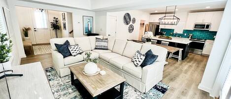 Expansive open floor layout featuring delightful coastal decor, offering convenient access to the home's rear patio.