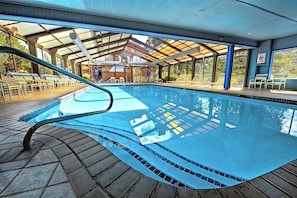 Indoor and outdoor swimming pool and poolside loungers