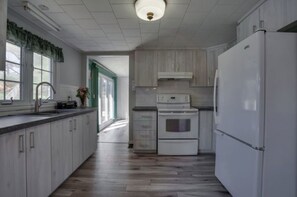 Kitchen with Stove, Fridge, Microwave, Plates and Utensils 