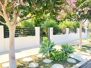 Gated front entry with lush green grounds. 