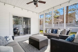 Nicely furnished screened in porch with ceiling fan