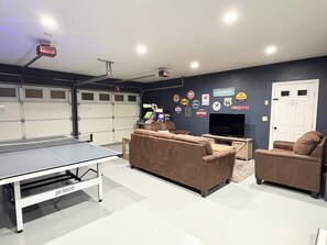 Garage game room features smart TV, ping pong table, Wii console & bar seating 