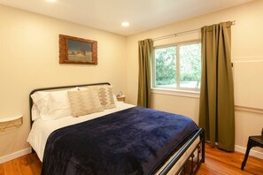 Second bedroom featuring stunning views of the landscaped yard and a majestic magnolia tree.
