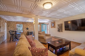 Lower level game room includes lounge seating, tv, darts, and more