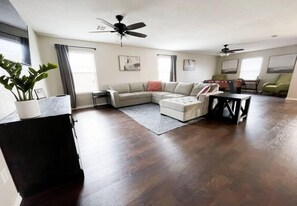 Large living room with foosball area and desk area on one end and seating area in the front