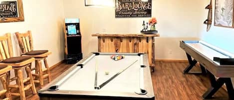 Game room with a pool table/ ping pong table, arcade, shuffleboard, and bar!