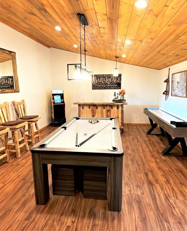 Game room with a pool table/ ping pong table, arcade, shuffleboard, and bar!