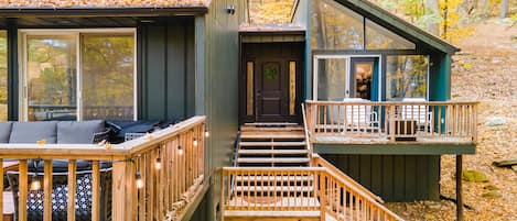 Front of cabin showing stairs to enter, primary bedroom and small deck on the right, and main deck on the left.