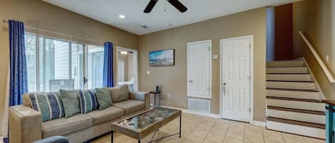 Open living room with lots of natural light. Blue couch lets out into twin bed