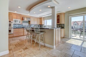 Gourmet entertaining kitchen with stainless appliances, island, and barstools.