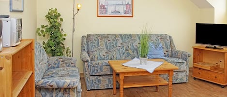 Wohnzimmer mit gemütlicher Sitzecke und Zugang zum Balkon