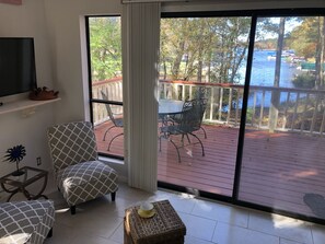 Livingroom opens to private deck beside Little River and overlooking the Lake!