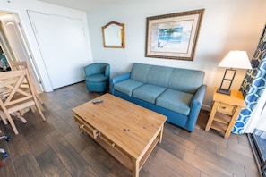 - Relax in this inviting living room, designed for comfort and laid back vibes - Large windows bring in plenty of natural light, creating a bright and airy feel - Unwind on the plush sofa or step onto the balcony for fresh ocean air
