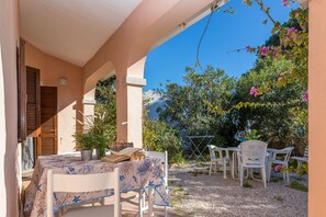 Extérieur avec terrasse couverte et table.