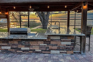 Outdoor BBQ gas grill and kitchen area with a sink and small refrigerator!