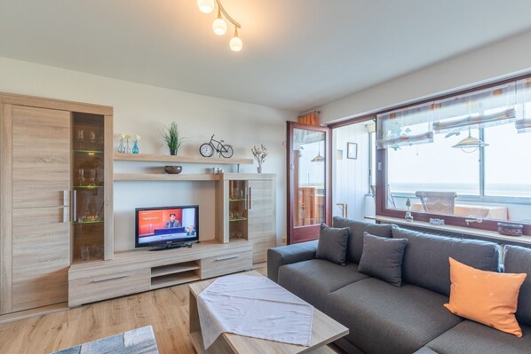Wohnzimmer mit Zugang zum verglasten Balkon