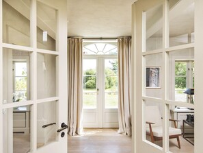 Wohnbereich mit großer Fensterfront und Zugang zur Terrasse