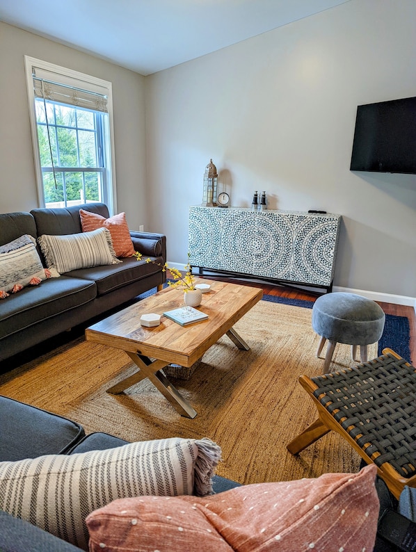 Living room with 2 couches and cabinet with games and puzzles.