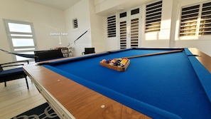Indoor entertainment area with pool table, 65" smart TV & domino table