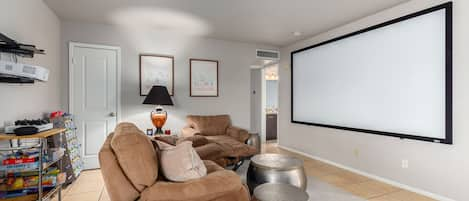 Living room with 10 foot movie screen and assorted games