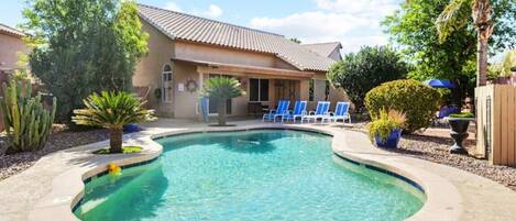 Backyard with pool (unheated), lounge chairs, and outdoor dining furniture.