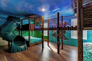 Dive into adventure in our Moana-themed bedroom! Featuring full-size bunk beds connected by a fun bridge and an exciting slide from the top bunks. Vibrant tropical decor and Moana details make this the perfect space for kids to dream and play!