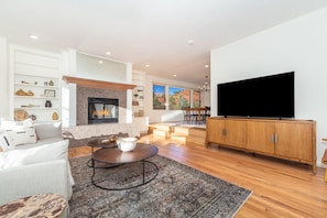 Step into the comfort of Sugarloaf House, where the spacious living area invites you to relax with plush seating, a cozy fireplace, and stunning red rock views.