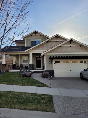 Front of house with grass area and large front porch. 