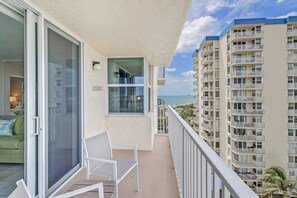 The sliding glass doors lead to the open balcony, where you catch a view of the gulf to the left.