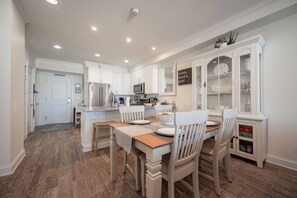 Fully stocked kitchen has counter stools and large dining table.