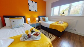 SRK Serviced Accommodation - Bright feature wall with beautiful soft furniture to match, with large window giving natural light. Master bedroom with ensuite