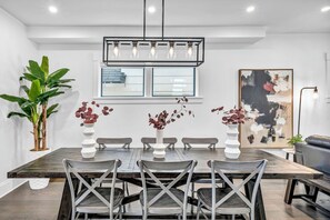 This stylish dining area offers a harmonious blend of modern design and cozy comfort, featuring chic decor, vibrant greenery, and ample natural light. Whether you're enjoying a family meal or entertaining guests, this inviting space promises to be the heart of your stay.