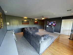 Large living room space with 65” LED TV. Coffee bar is around the corner.