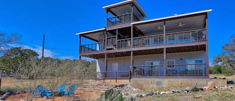 The back of the house features multi-level decks facing Canyon Lake.