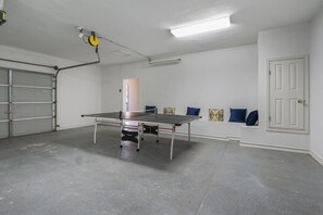 The garage on the ground floor has been converted to a game space with a ping pong table.