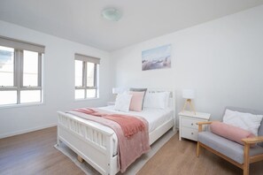 [Bedroom] A modern, bright bedroom with an amazingly comfortable mattress, soft pillows, hotel-grade sheeting for your comfort, and an additional seat.