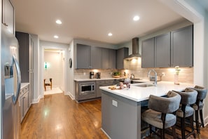 2nd Floor: Fully equipped kitchen with stainless steel appliances and breakfast bar seating.