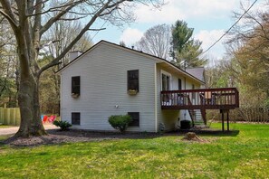 Front of house showing back deck with grill and patio table