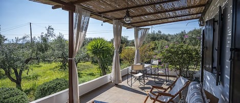 Terrace with 3 person sofa, two deck chairs and marble table for meals