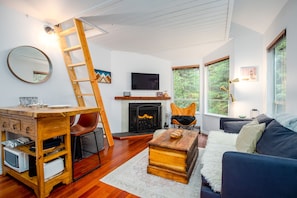 Living Room - Open space, cozy interior, real wood fireplace, rustic furnishings, SmartTV, intimate forest setting.