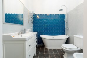 The bathroom's contemporary design includes fresh towels and a hairdryer. 