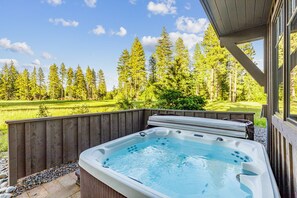 Spa retreat with bubbling jets and woodland backdrop for ultimate relaxation.