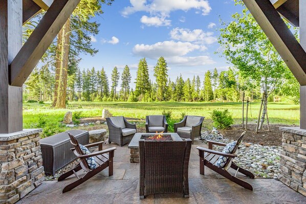 Stone gas firepit surrounded by Adirondack chairs—perfect for evening gatherings