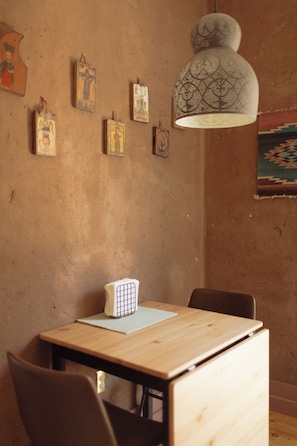 The cozy dining nook in the kitchen features exposed adobe plaster walls