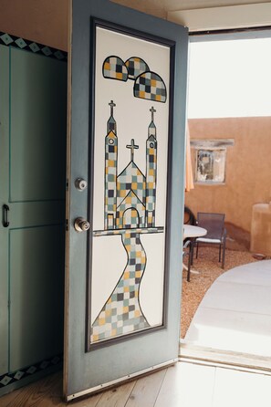 This painted glass door in the bedroom opens out to a patio with a table and chiminea for chilly fall evenings