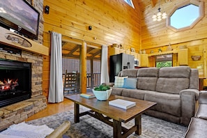 Open concept living room with electric fireplace and new leather sofas. 