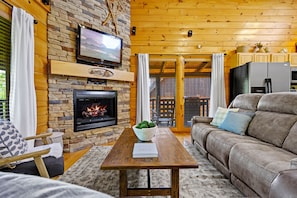 Open concept living room with electric fireplace and new leather sofas. 